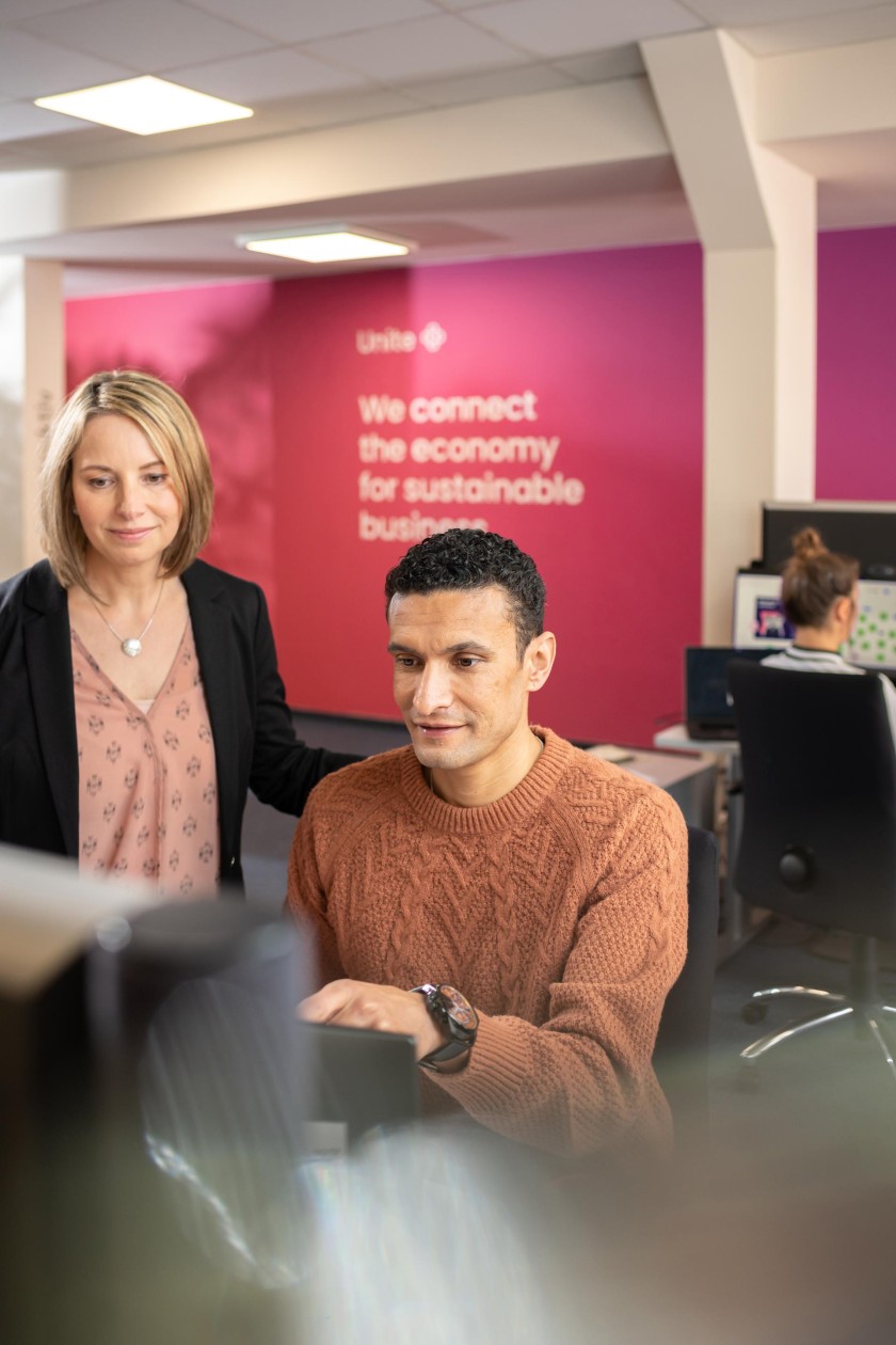 Twee collega's kijken op een computerscherm op kantoor 