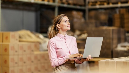 Una operaria del almacén controla los niveles de stock desde su portátil 