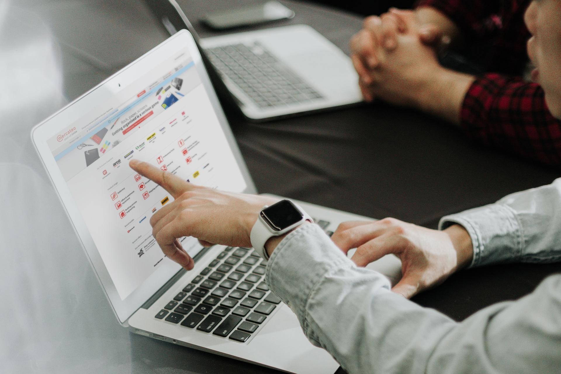 Procurement professional pointing at the Mercateo Marketplace on a laptop 