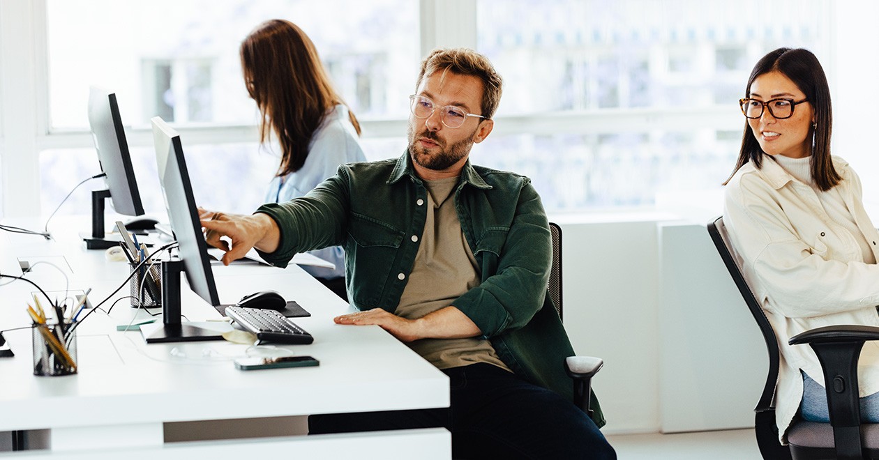 Zwei Beschaffungsexpert*innen diskutieren im Büro über Anforderungen