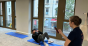 Ein junger Mann macht Sit-ups, während eine Frau seine Zeit misst
