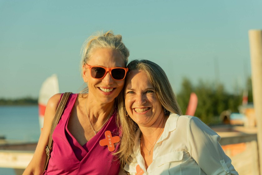 Twee vrouwen lachen in de zon op het Unite zomerfeest