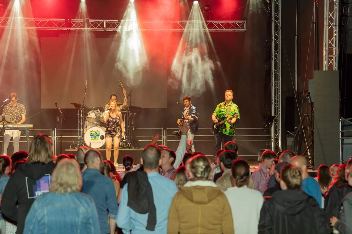 Band speelt op een podium en mensen dansen.