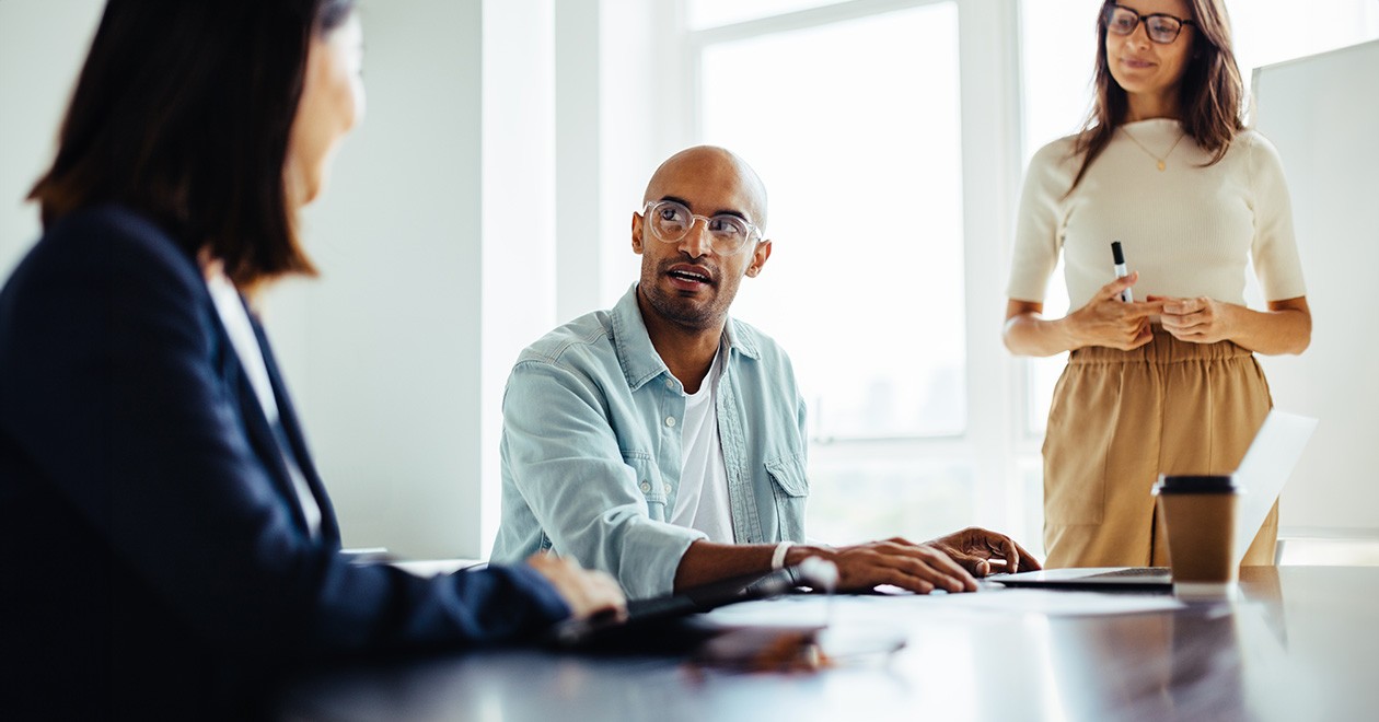 Three procurement professionals in a meeting room speak about solutions for unethical behaviour