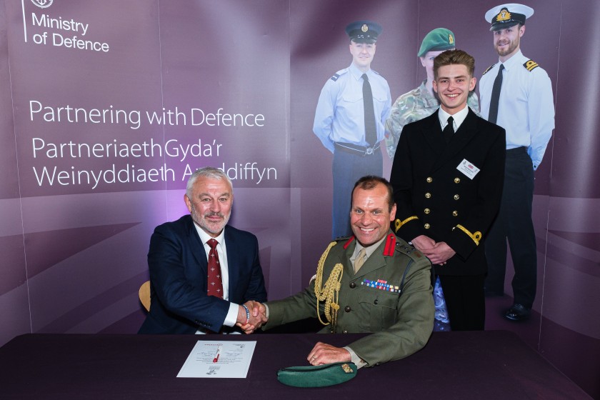 Two men shake hands after Unite signs the Armed Forces Covenant Pledge